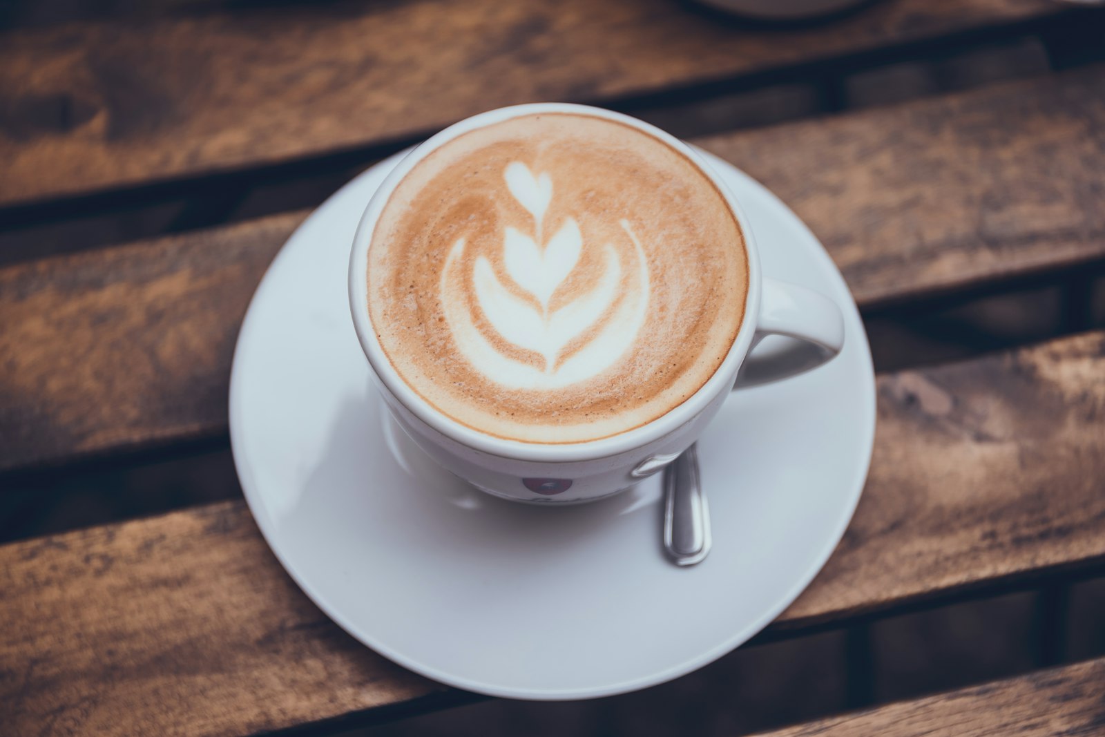 A real cup of coffee with a rosetta poured into the crema, seen from above